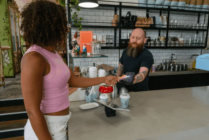 Person tapping card on Tyro Pro in a cafe