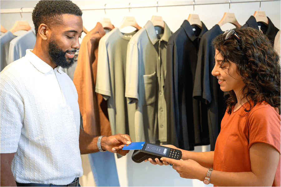 2 people in a clothing retail store tapping a card on a tyro pro