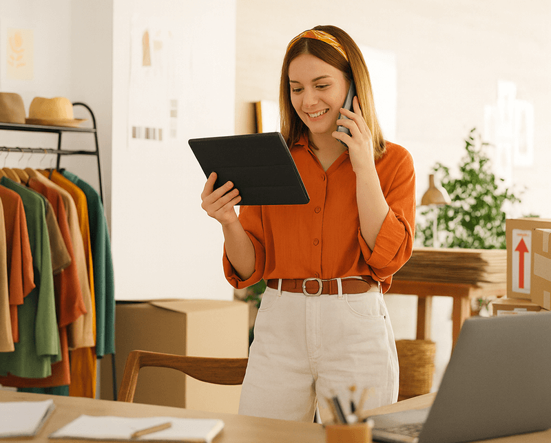 Person talking on phone and looking at a tablet.