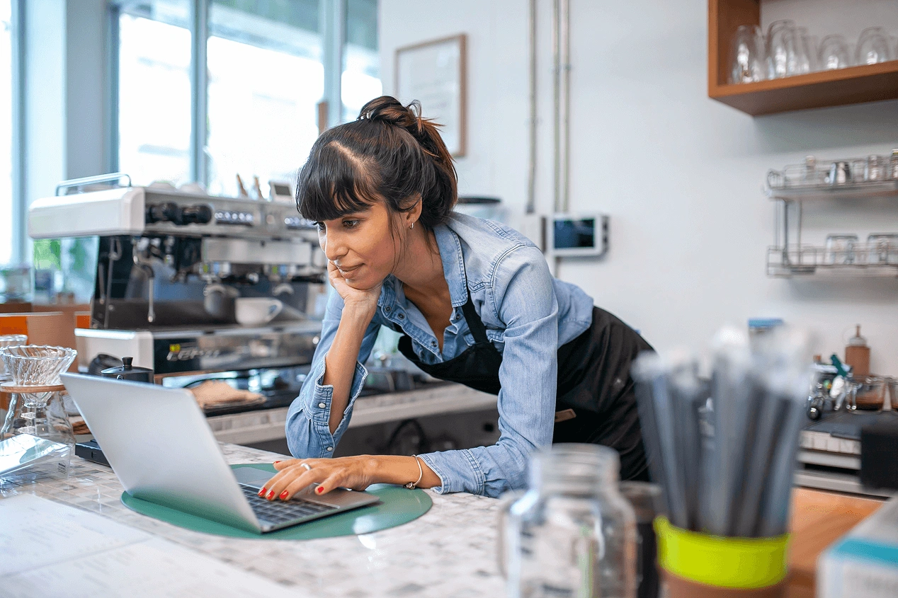 Cafe owner looking at business loans on her computer