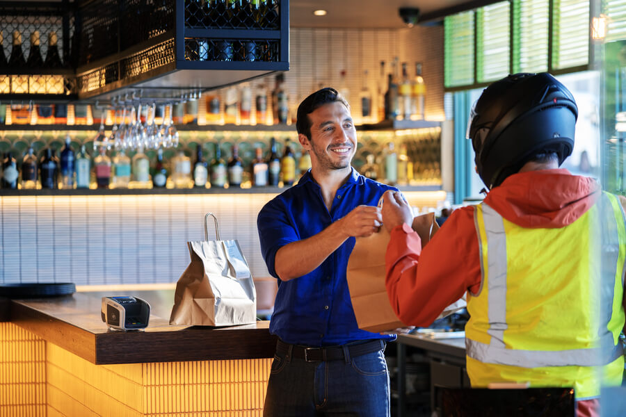 Food delivery driver picking up takeaway from a restaurant