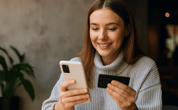 Person looking at phone and card smiling