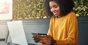 Person looking at phone and credit card