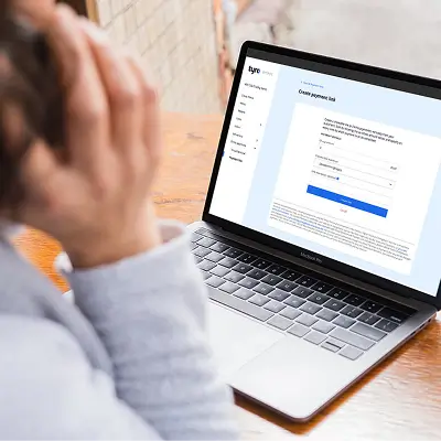 Person on phone with laptop open