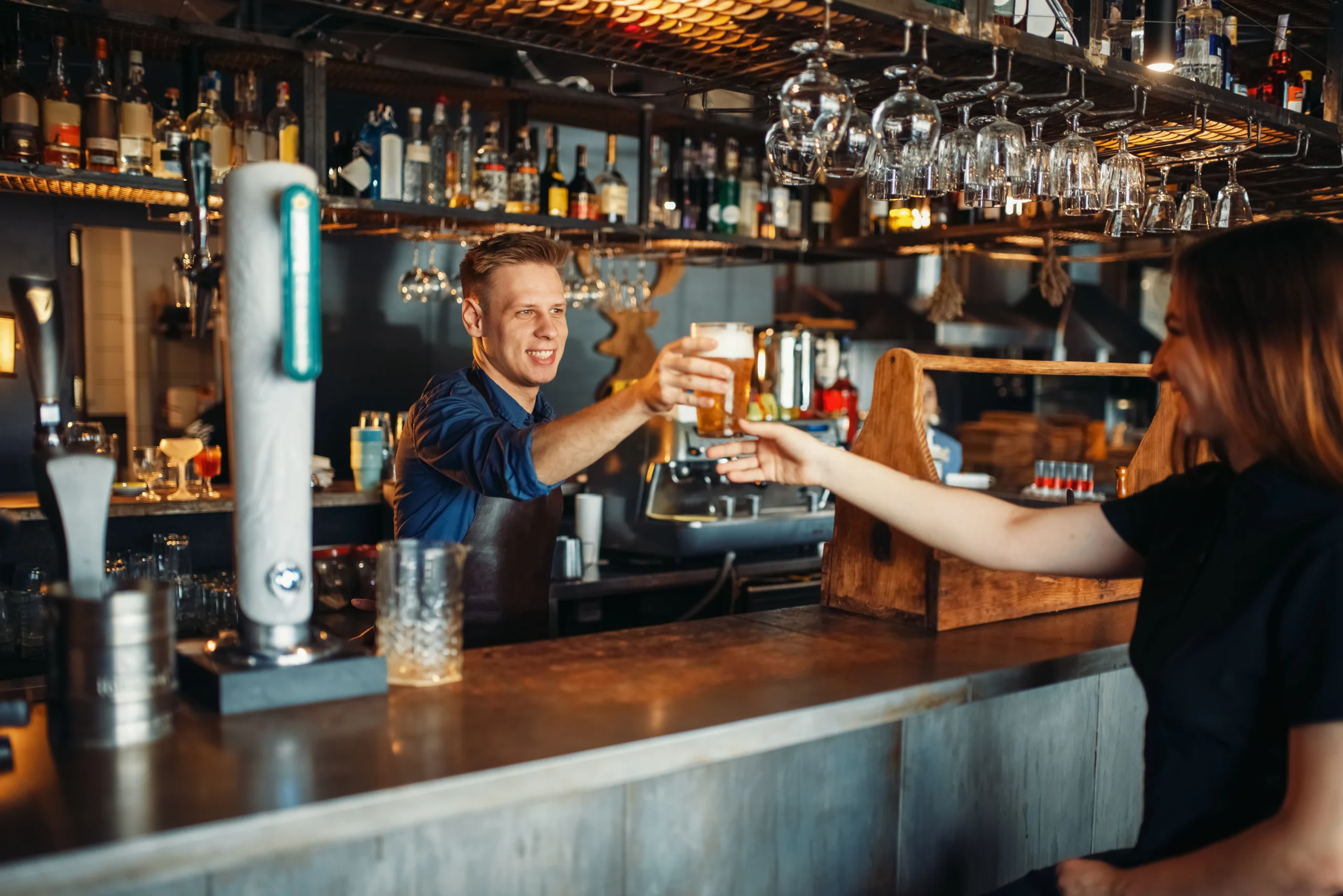 pub server handing a beer to customer