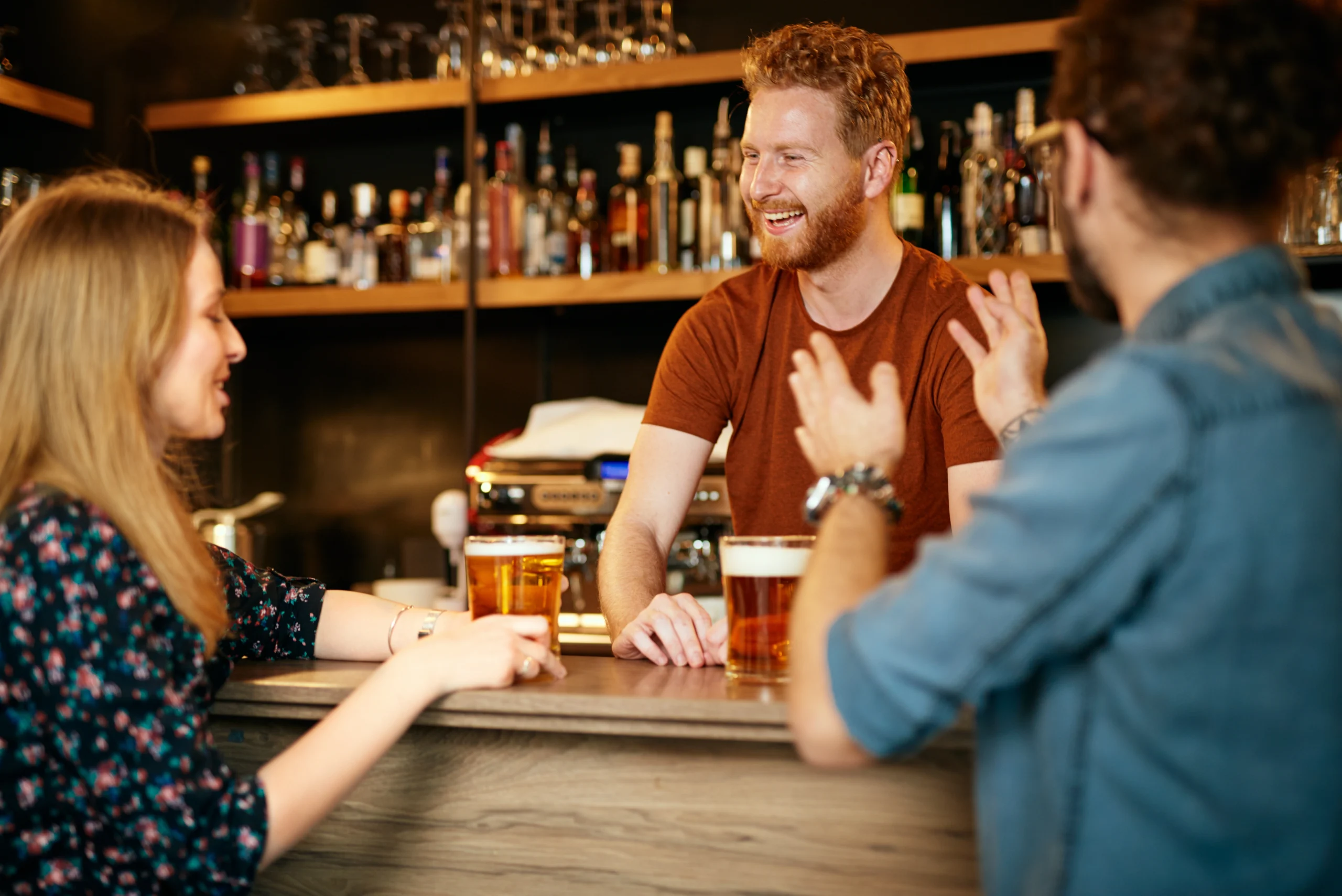 Bar owner serves beer at the bar counter