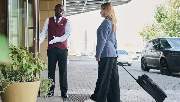 Doorman opening door for person