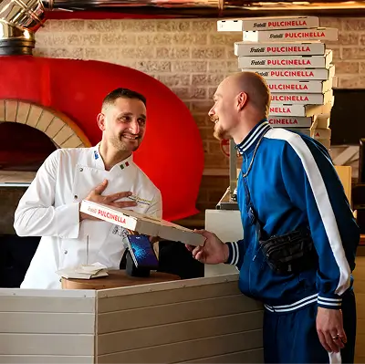 People laughing tapping a pizza box onto a tyro pro touch