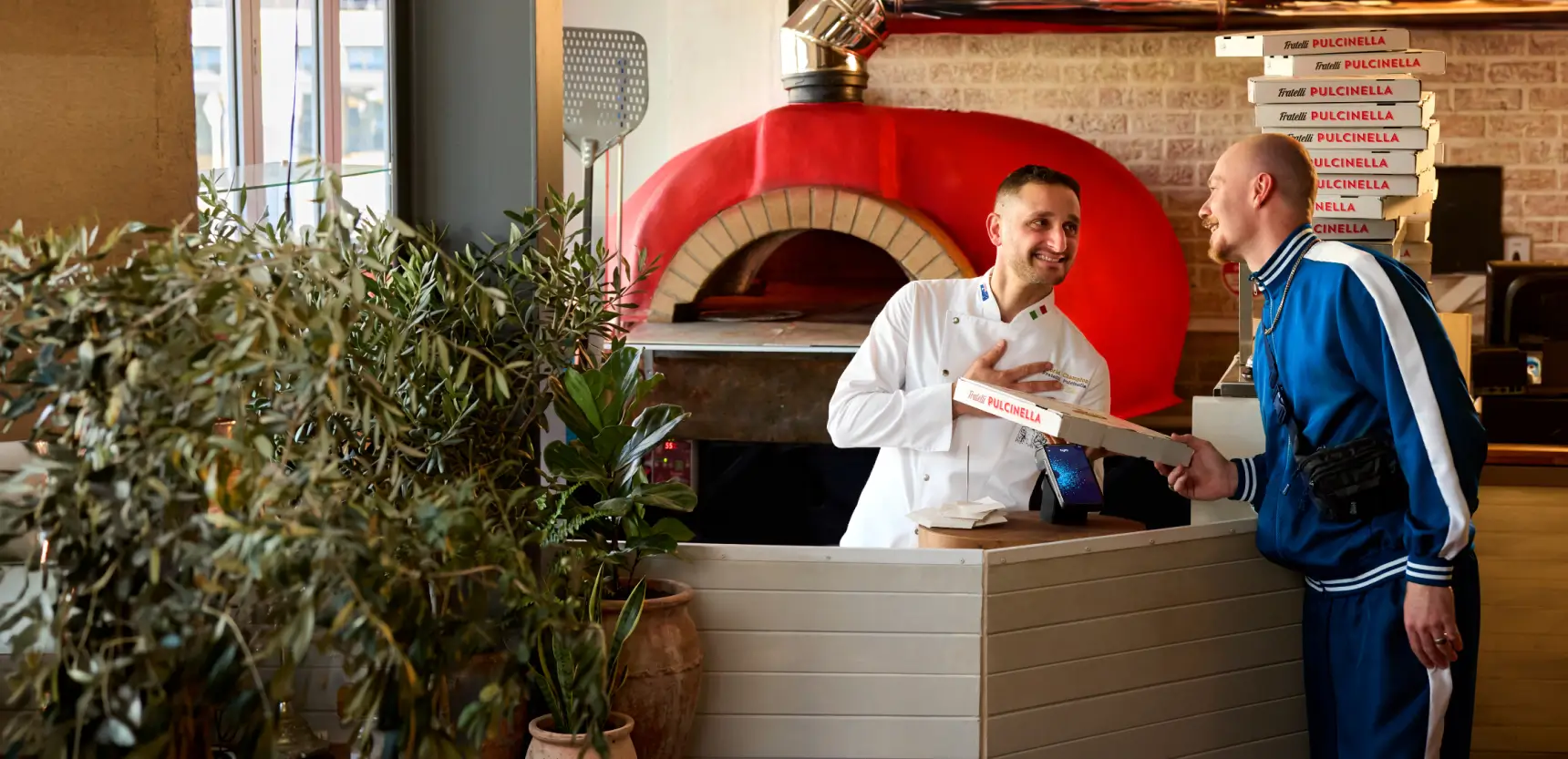 People laughing tapping a pizza box onto a tyro pro touch