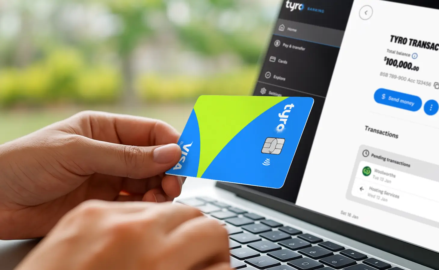 Person holding the Tyro Visa Debit card in front of a laptop
